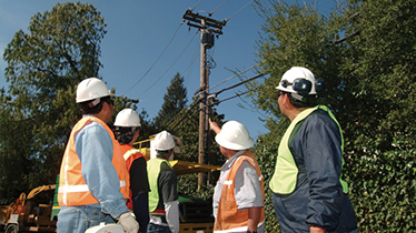 Workers pointing at overhead powerline